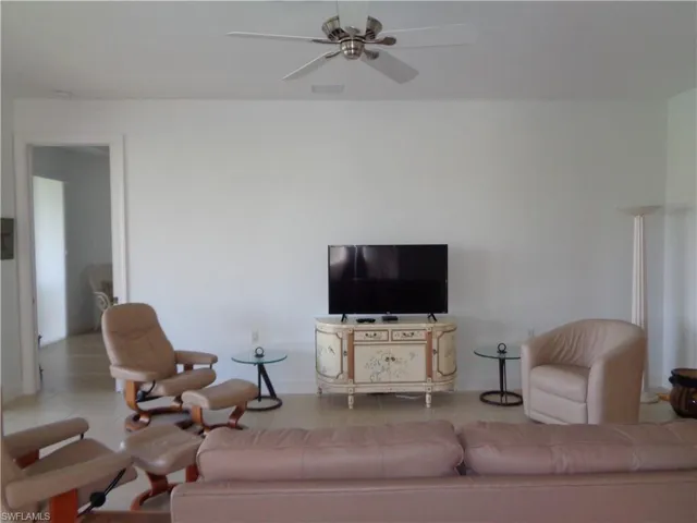 Tiled living room featuring a ceiling fan