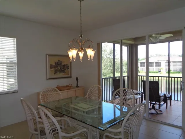 Dining area featuring light tile patterned floors, a chandelier, and ceiling fan