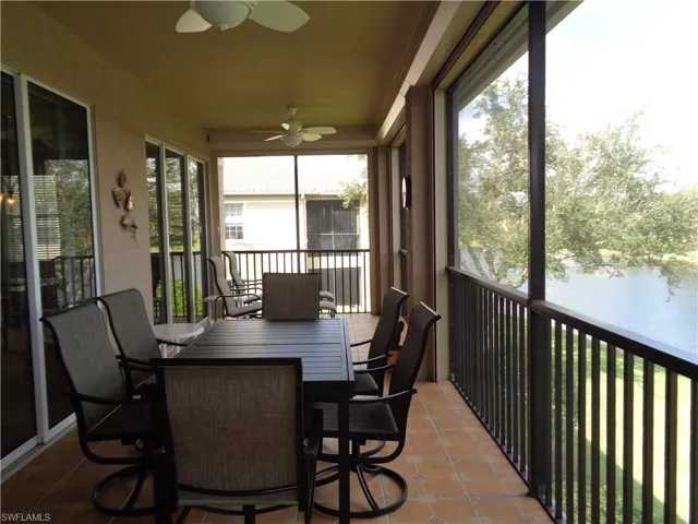Sunroom / solarium featuring ceiling fan, a water view, tile patterned flooring, and outdoor dining space