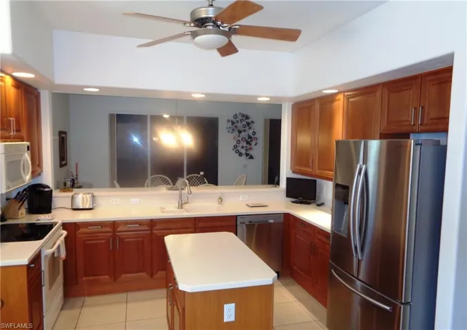 Kitchen with appliances with stainless steel finishes, recessed lighting, light countertops, a center island, and a peninsula
