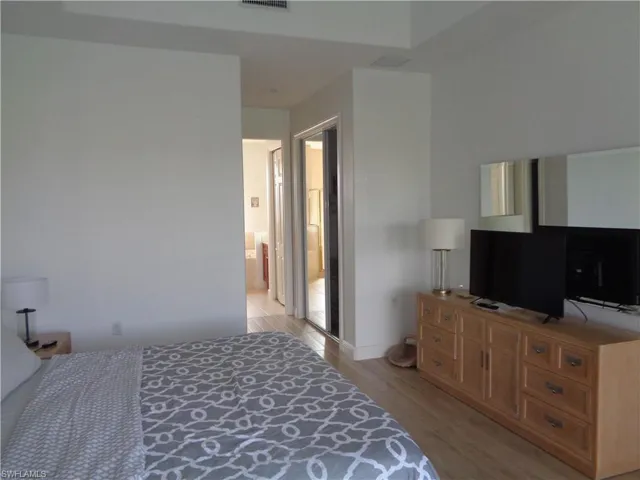 Bedroom featuring light wood finished floors and connected bathroom