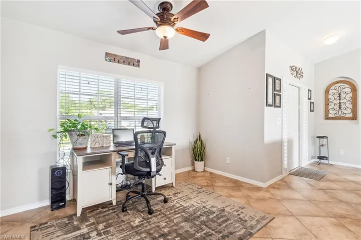 Office with tile flooring, ceiling fan, and vaulted ceiling