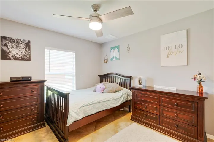 Bedroom featuring ceiling fan and light tile floors