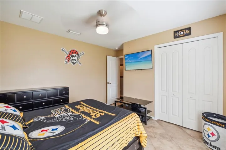 Tiled bedroom with a closet and ceiling fan