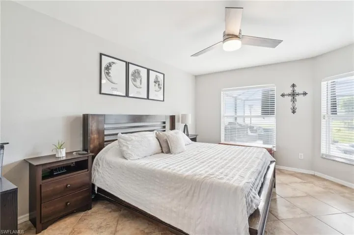 Bedroom with ceiling fan and light tile flooring