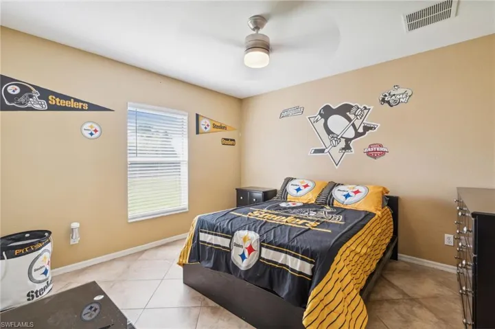 Tiled bedroom featuring ceiling fan