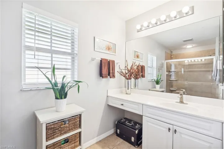 Bathroom featuring a wealth of natural light, tile flooring, vanity, and toilet