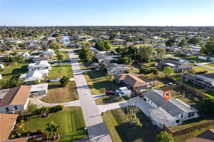 Aerial view of property and surrounding area featuring nearby suburban area