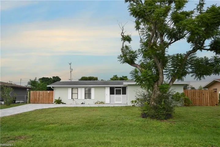 Ranch-style house with stucco siding and driveway