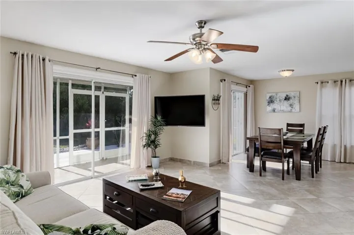 Living area featuring ceiling fan and light tile patterned flooring