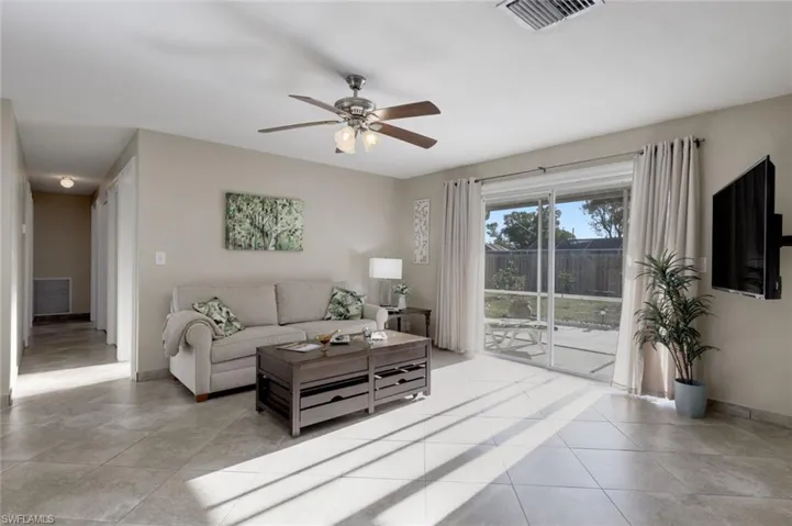 Living area featuring ceiling fan and light tile patterned flooring