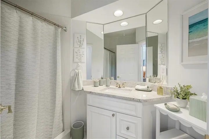 Bathroom featuring a shower with curtain and vanity