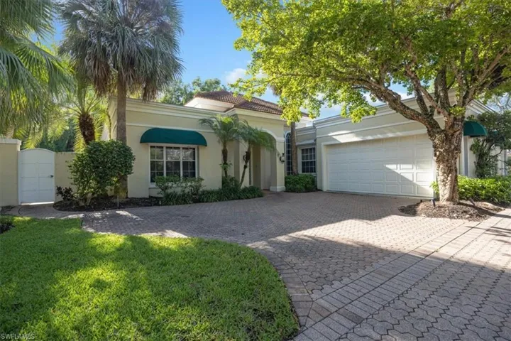 Mediterranean / spanish-style home with a gate, decorative driveway, stucco siding, a garage, and a front yard