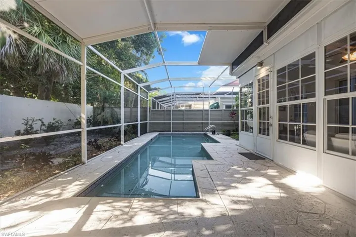 View of pool featuring a sunroom, a fenced backyard, a patio area, and a lanai