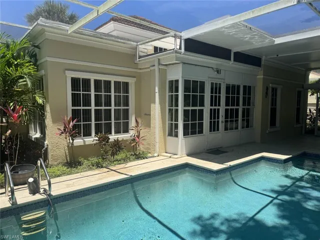 Swimming pool featuring a patio area and glass enclosure