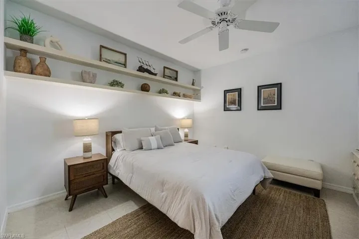 Bedroom with ceiling fan and light tile patterned floors