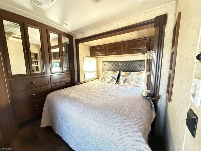 Bedroom with cooling unit and wood finished floors