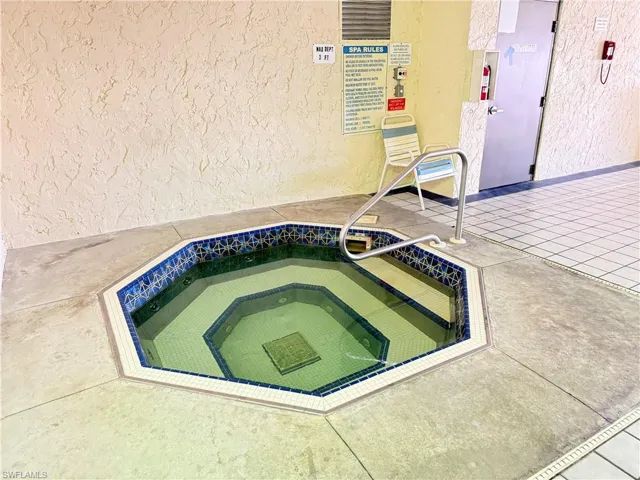 View of swimming pool with a community hot tub