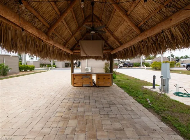 View of patio with exterior kitchen, a gazebo, and ceiling fan