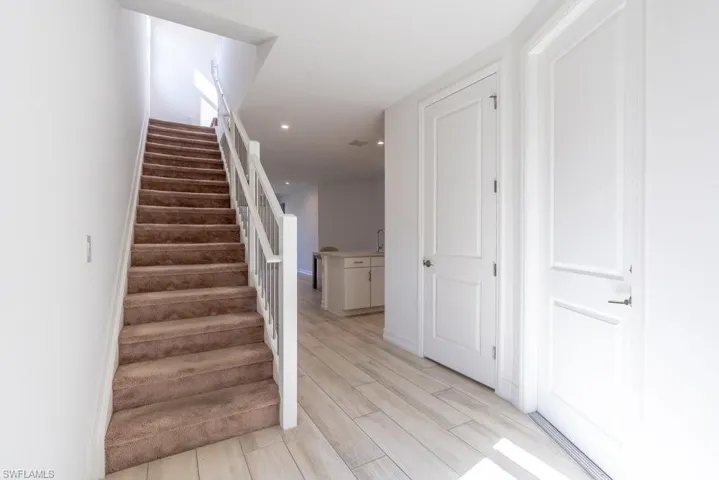 Stairs featuring wood finish floors and recessed lighting