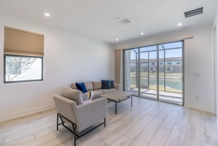 Living room with wood finish floors, a water view, plenty of natural light, and recessed lighting