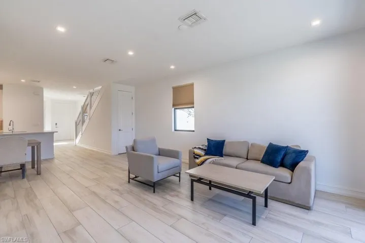 Living area with recessed lighting and wood finish floors