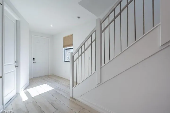 Entryway with wood finish floors and stairs