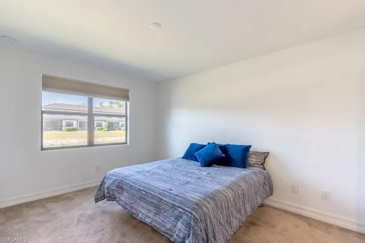 Carpeted bedroom featuring baseboards