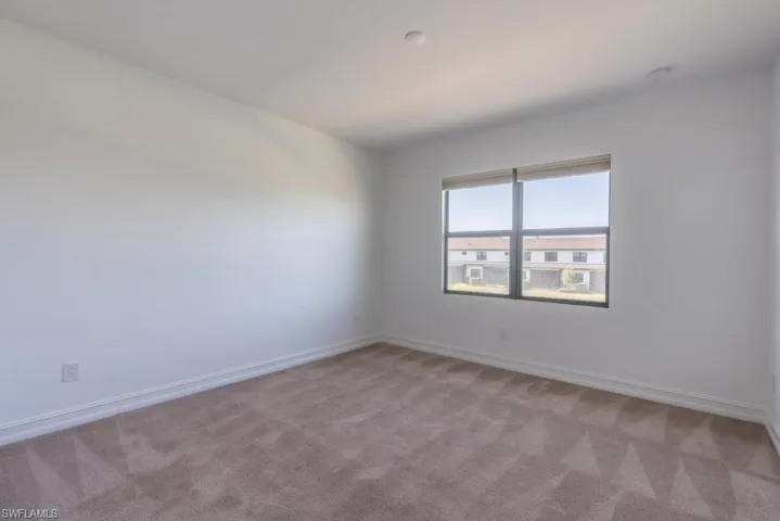 Carpeted empty room with baseboards