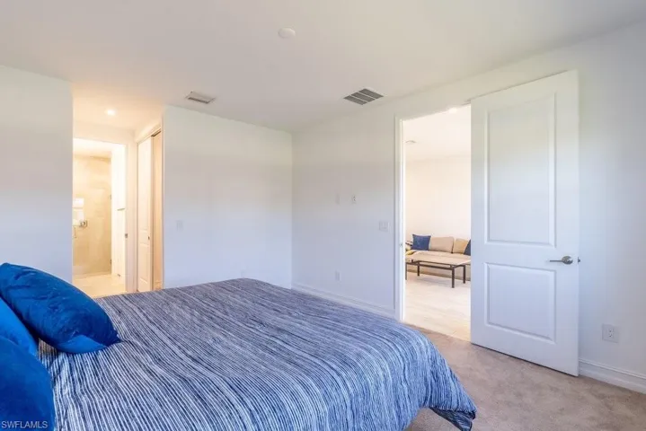 Bedroom featuring light carpet and baseboards