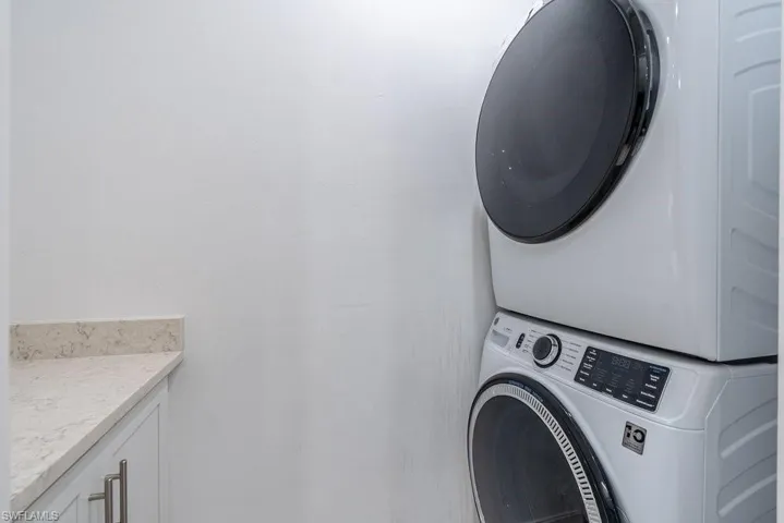 Laundry area with stacked washer and clothes dryer