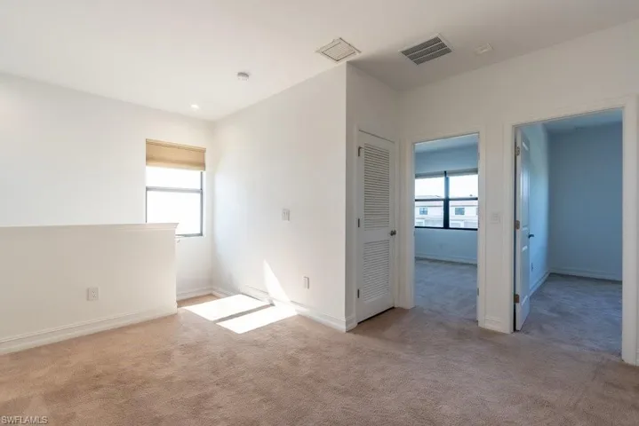 Spare room with plenty of natural light and light colored carpet