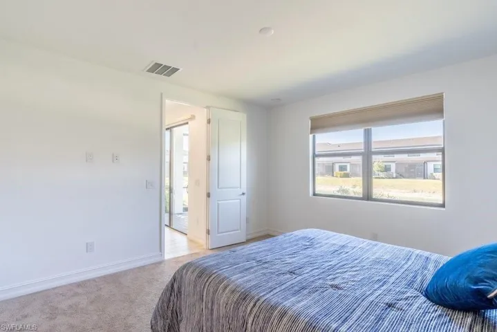 Bedroom featuring baseboards and light carpet