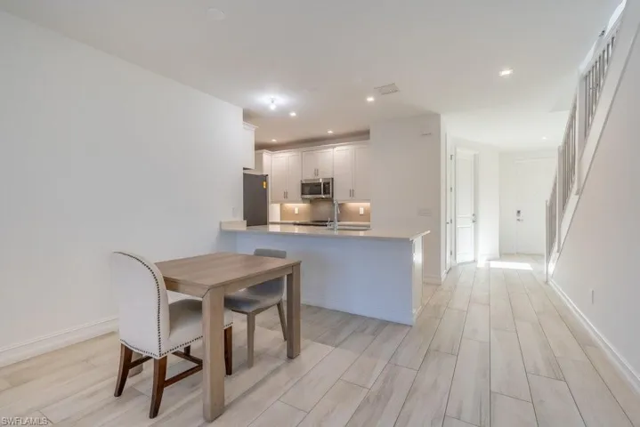 Dining room featuring wood finish floors, stairs, and recessed lighting