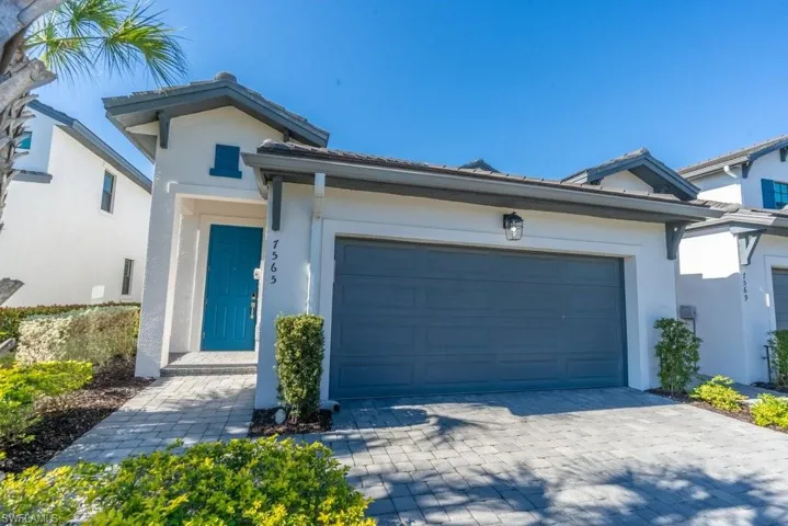 Single story home featuring stucco siding, decorative driveway, and an attached garage