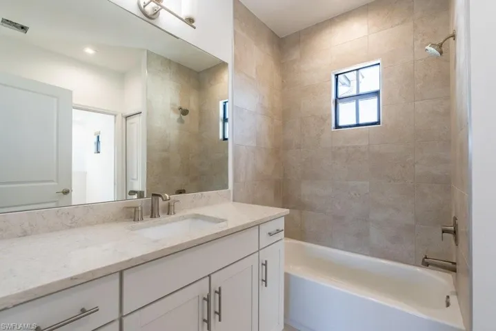 Bathroom featuring vanity and shower / bathtub combination