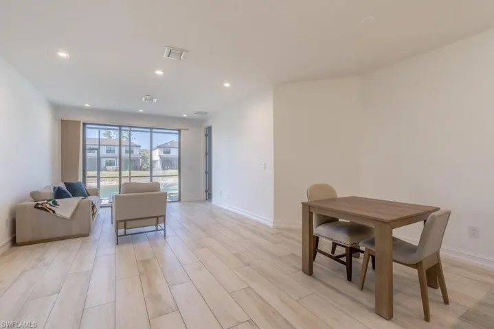 Dining space with wood finish floors and recessed lighting