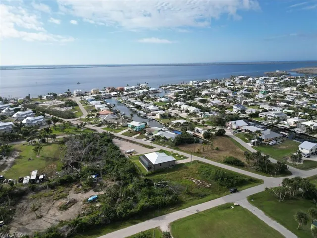 Aerial view of property and surrounding area with nearby suburban area and a large body of water