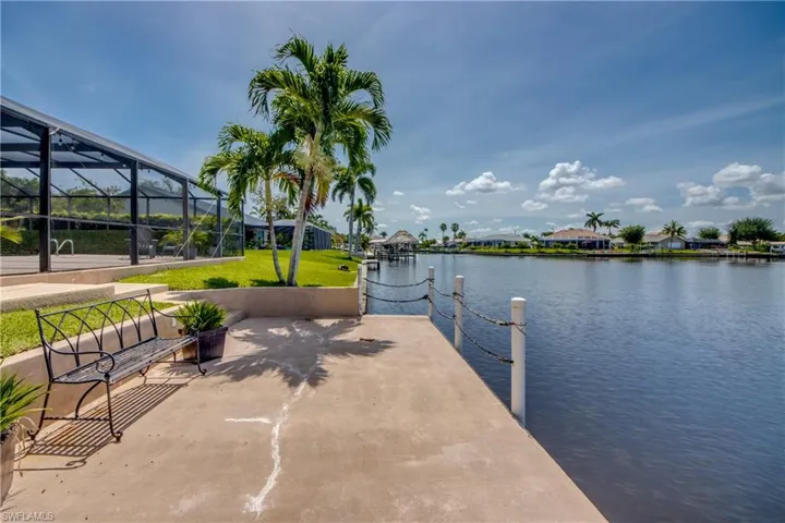 Dock featuring a water view, a yard, and a lanai