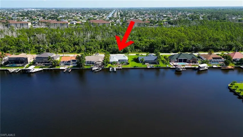 Aerial view of property and surrounding area with nearby suburban area and a large body of water