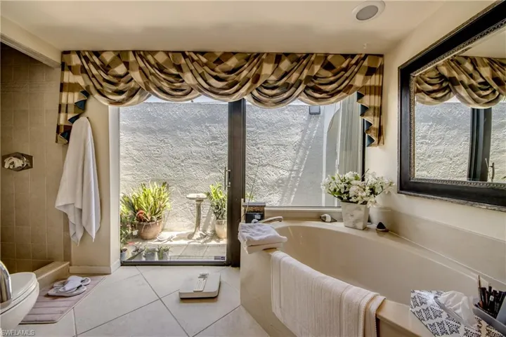 Full bathroom featuring a garden tub, tile patterned flooring, and tiled shower