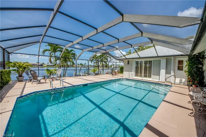Outdoor pool with a patio, a water view, and a lanai