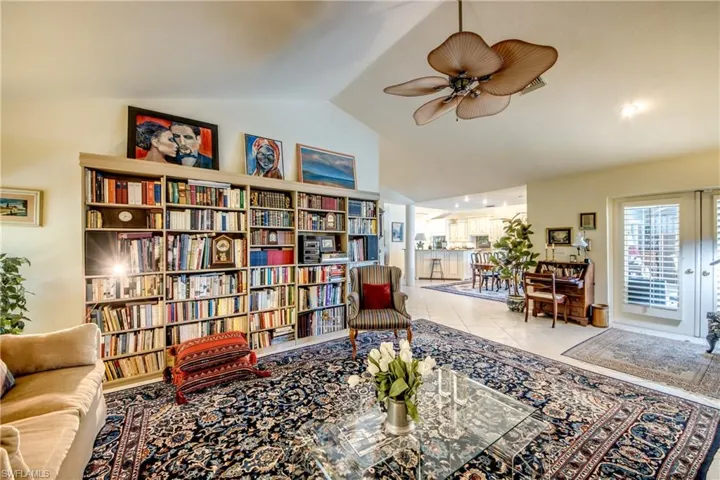 Sitting room with vaulted ceiling, ceiling fan, and light tile patterned floors