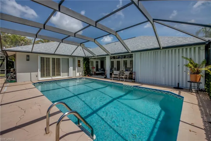 Outdoor pool featuring a patio, glass enclosure, and a ceiling fan