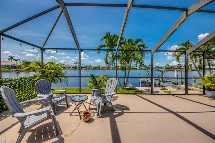 View of patio with a water view, a lanai, and boat lift