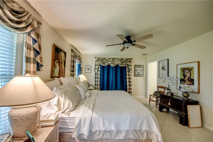 Bedroom with light tile patterned floors and ceiling fan