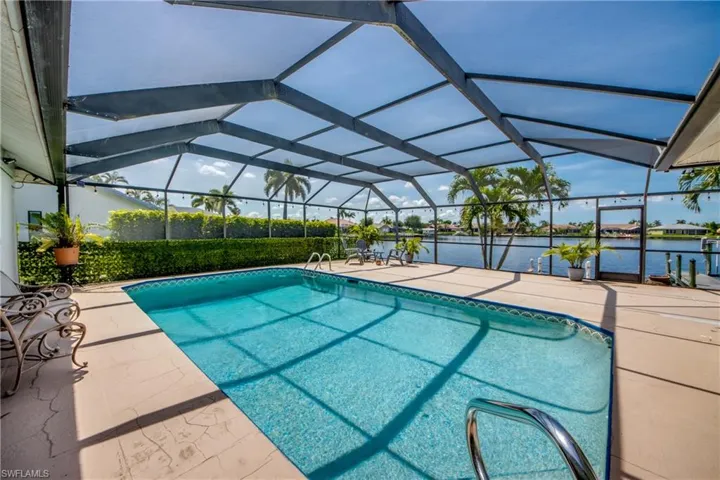 Outdoor pool with a patio, a water view, and a lanai
