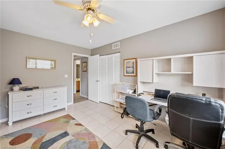 Office space with light tile patterned flooring and a ceiling fan