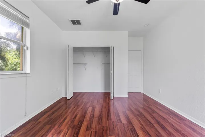 Unfurnished bedroom with a closet, wood finished floors, and ceiling fan
