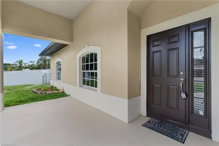 Entrance to property with stucco siding and a patio area